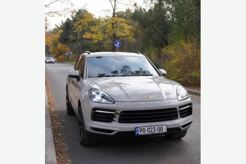 Серый Porsche Cayenne S на осенней дороге