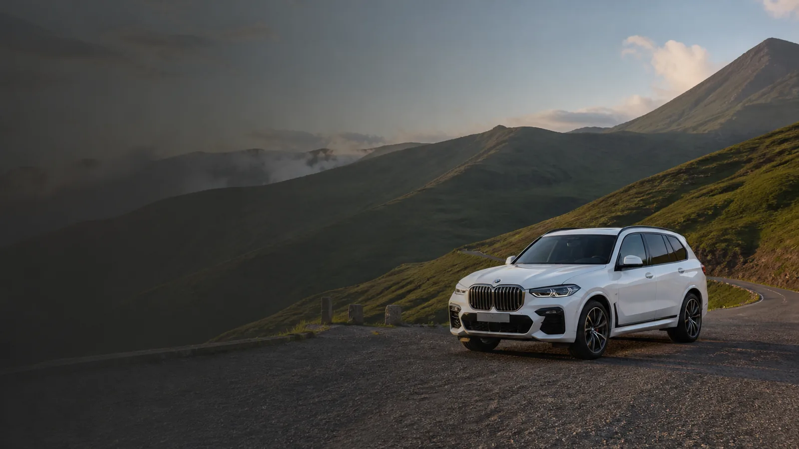 Белый BMW X7 M50i 2020 из автопарка Geo Car com на дороге в горах Грузии